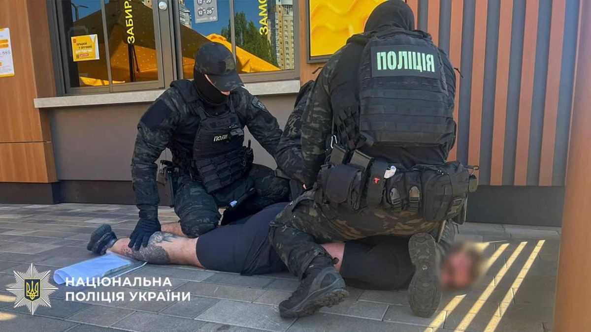 Киянин продавав відстрочки від армії за $28 000 Поліцейські у бронежилетах затримують підозрюваного на землі біля входу у заклад швидкого харчування у Києві