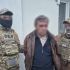 Співробітники контррозвідки СБУ в балаклавах і розмитий затриманий чоловік біля будинку на Київщині