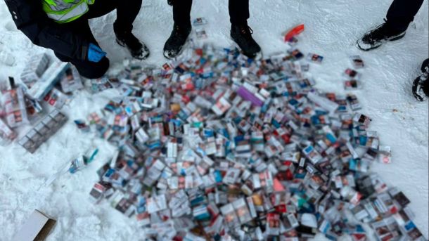 Вилучена тютюнова продукція, розсипана на снігу під час огляду поліцейськими місця злочину у Дніпровському районі Києва