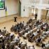 Головні новини Києва | Kyiv.News Громадські слухання у залі з проєкцією проєкту Музею Революції Гідності, українськими прапорами та учасниками на стільцях у Києві