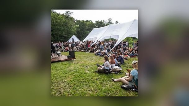 «Путін робить це, бо може»: Зеленський і МЗС про масований терор РФ під час саміту G7 Відвідувачі фестивалю «Протасів Яр» сидять на траві біля білих шатер під час події памʼяті Романа Ратушного в Києві