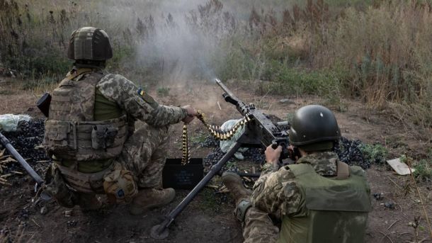 Двоє військових на позиції працюють з кулеметом