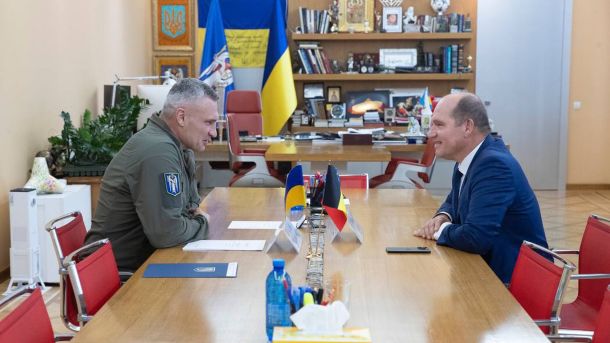 Віталій Кличко сидить за столом разом із мером Брюсселя Філіпом Клозом, вони посміхаються один одному