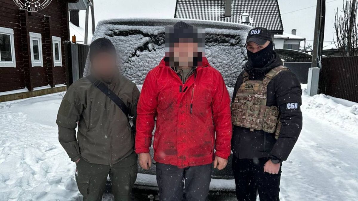 Співробітники СБУ конвоюють затриманого підозрюваного у державній зраді на засніженій вулиці Вишгородського району, обличчя підозрюваного заблюроване