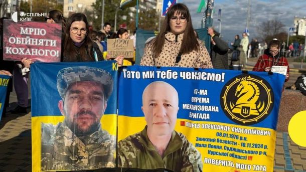Учасниці акції тримають банер із фото полонених військових та закликом повернути їх додому