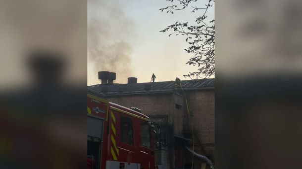 Рятувальники ДСНС на даху цегляного павільйону Кіностудії Довженка в Києві, поруч пожежна машина й дим