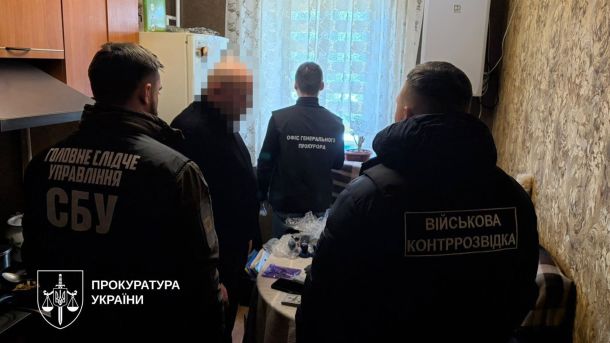 Затриманий підозрюваний у своєму помешканні. Поруч правоохоронці