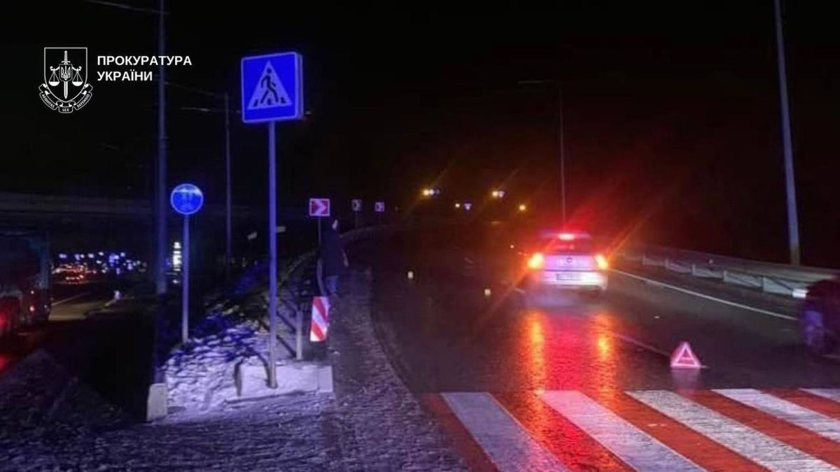 Нічний пішохідний перехід на Оболоні зі знаком аварійної зупинки та автомобілем з увімкненими фарами — місце ДТП