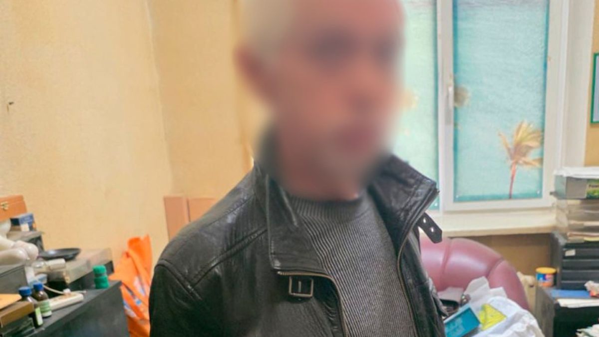 Чоловік у чорній шкіряній куртці з розмитим обличчям у поліцейському відділку — підозрюваний у розгромі кав'ярні у Шевченківському районі Києва