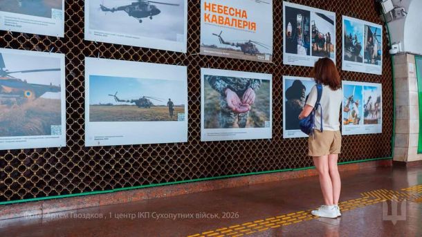 Відвідувачка розглядає фотовиставку Небесна кавалерія про українських авіаторів на станції метро Площа Українських Героїв у Києві, липень 2026 року