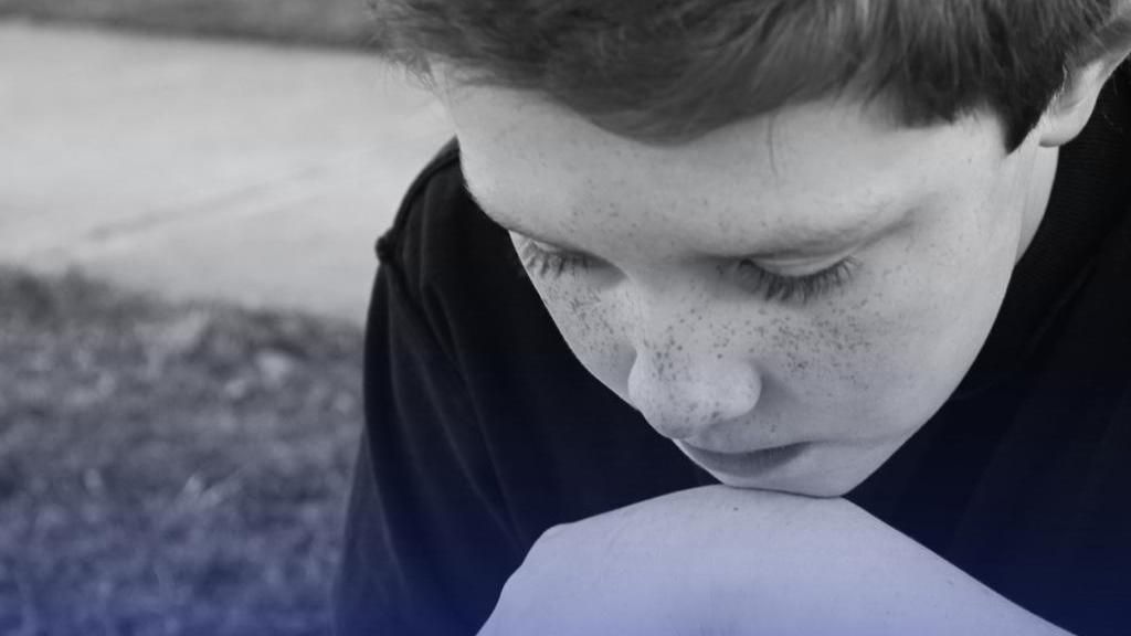 Засмучений хлопець, який поклав голову на руку