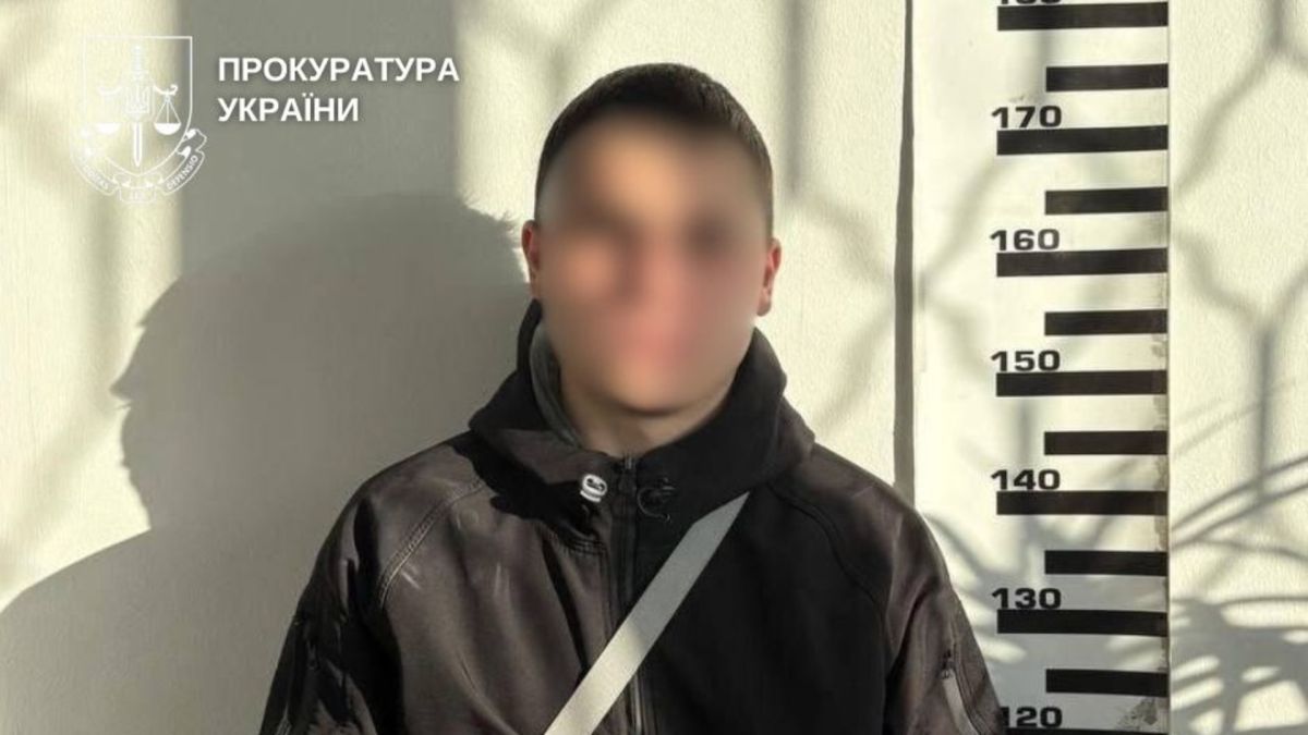 Підозрюваний у шахрайстві з дронами для ЗСУ біля ростоміра у відділку, обличчя заблюроване, водяний знак Прокуратури України