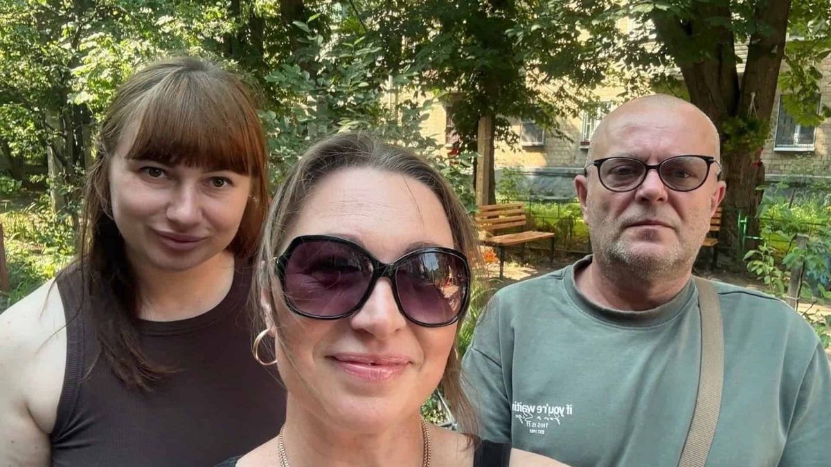 Троє активістів вулиці Сокальської на Оболоні позують для селфі у дворі серед зелені під час зустрічі з представниками РМБО
