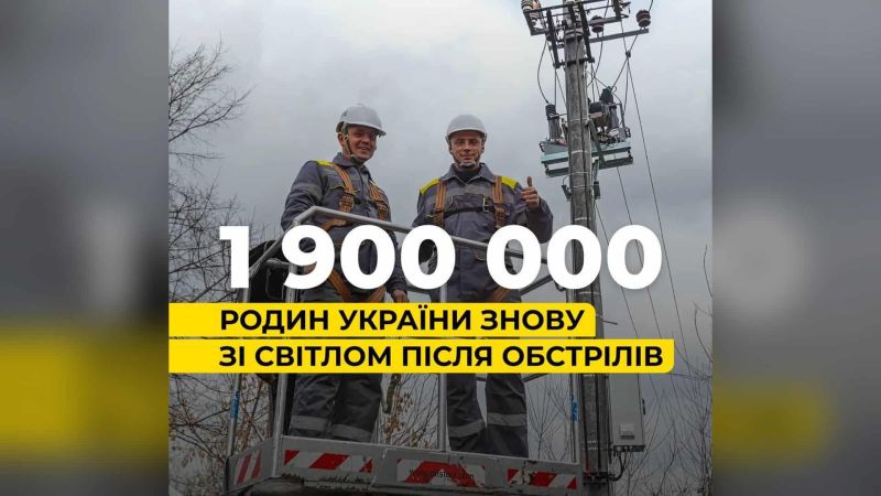 Двоє енергетиків ДТЕК у касках на автовишці біля опори лінії електропередачі після відновлення світла