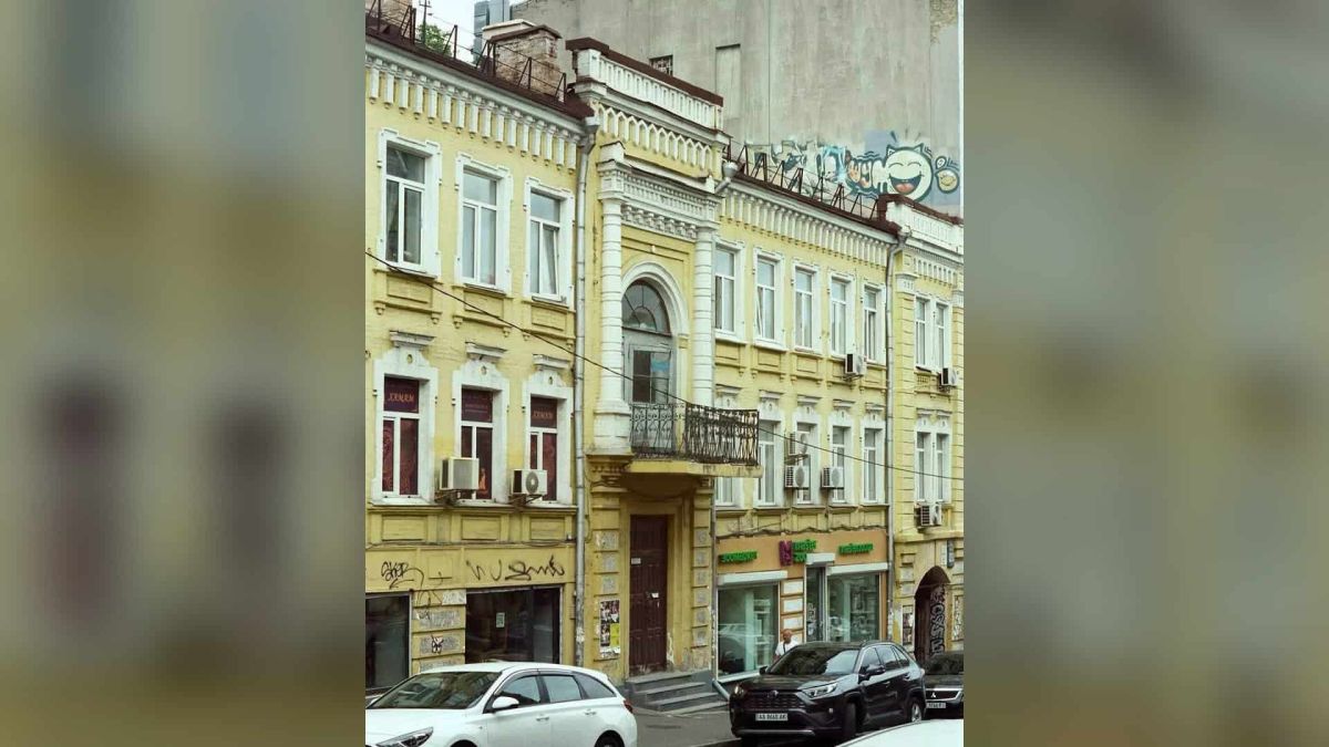 Будинок на Прорізній, 22А: фасад із фігурної цегли й двоколонним портиком Сучасний вигляд триповерхового будинку на Прорізній, 22А у Києві: жовтий фасад, балкон із двоколонним портиком і арковий вхід