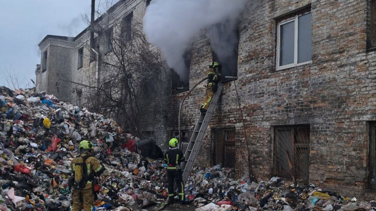 Рятувальники ДСНС гасять пожежу на другому поверсі закинутої цегляної будівлі на вулиці Деревообробній у Голосіївському районі, навколо будівлі купи сміття