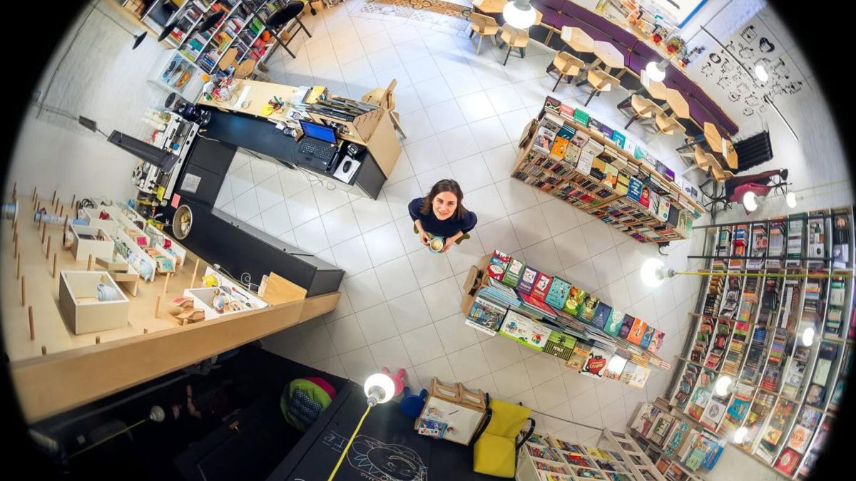 Засновниця книгарні «Моя книжкова полиця» Наталія Моспан стоїть посеред торгового залу, оточена стелажами з україномовними книгами