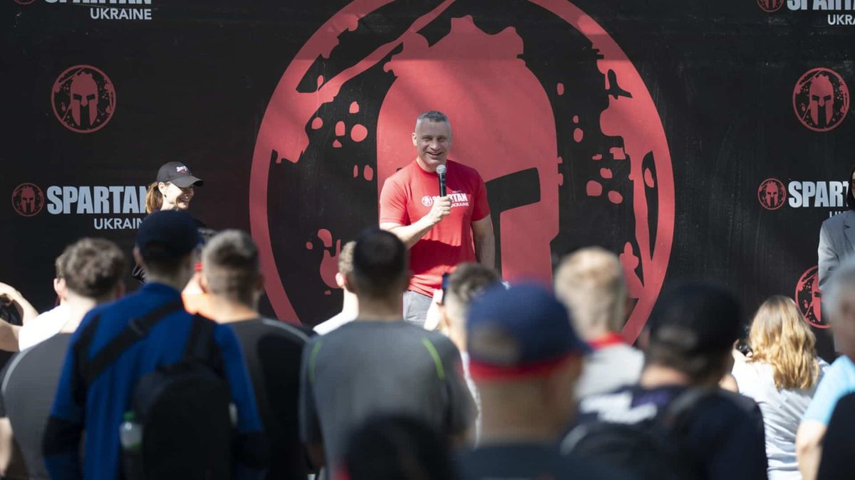 Мер Києва Віталій Кличко виступає з мікрофоном на відкритті змагань Spartan Kyiv 2026 на Трухановому острові на тлі банера Spartan Ukraine