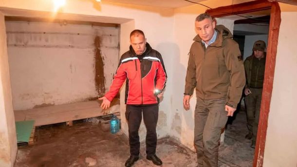 Мер Києва Віталій Кличко з рятувальником оглядає підвальне приміщення, обладнане під укриття, у супроводі військових