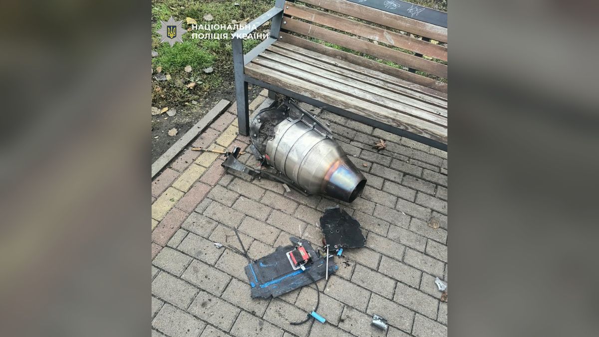 Уламки безпілотника біля лавки на тротуарі під час документування наслідків атаки на Київ