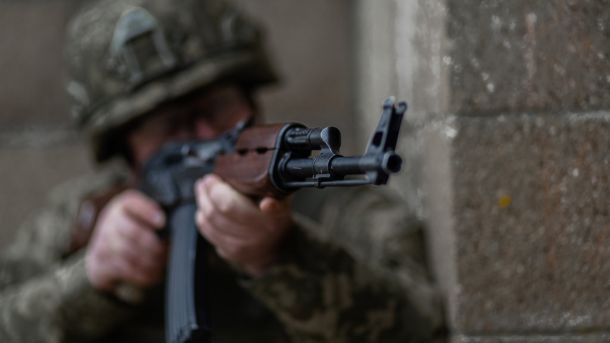 Боєць ЗСУ тримає автомат і прицілюється