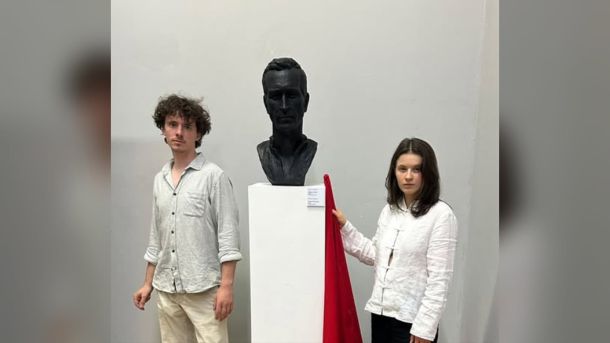 Пам’ятник художнику і воїну Давиду Чичкану на Байковому кладовищі у Києві, поруч стоять двоє людей