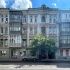 Цегляний прибутковий будинок на Великій Житомирській 31 у Києві початку ХХ століття з арковими вікнами та фронтоном