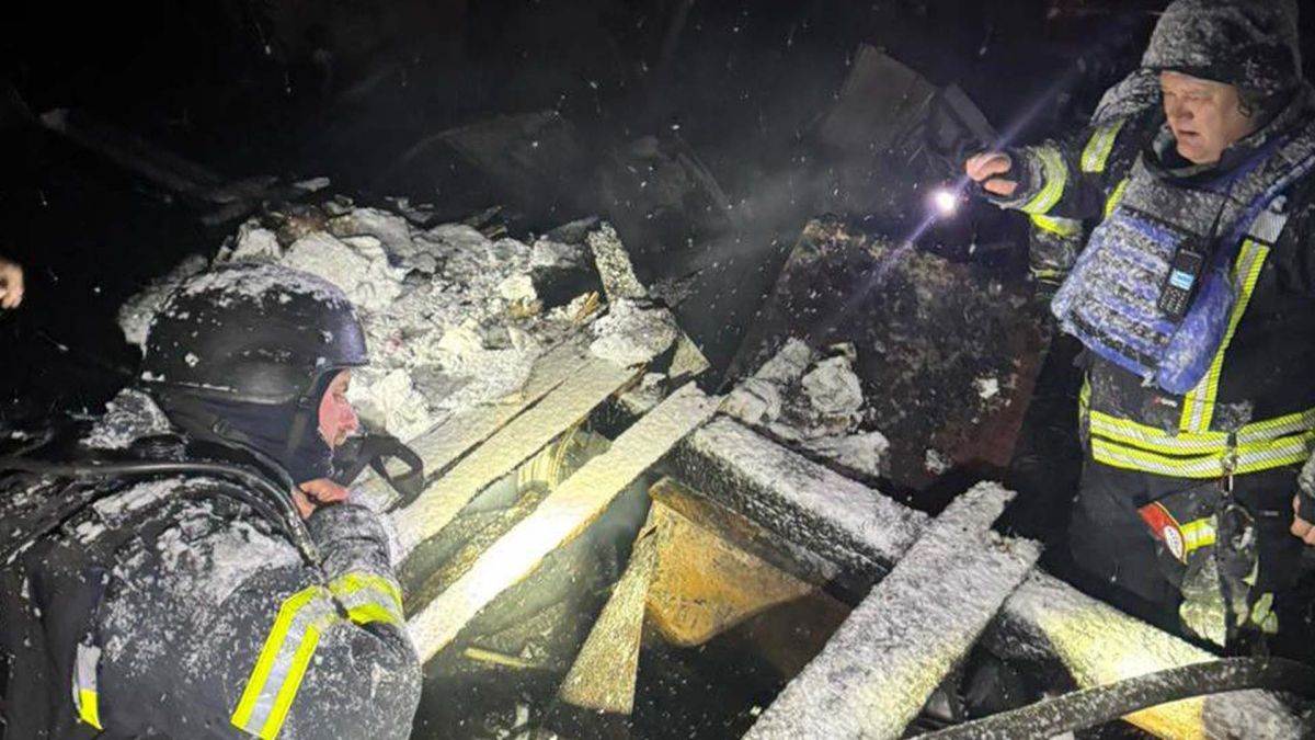 Двоє рятувальників оглядають зруйновану будівлю