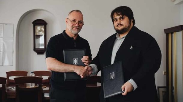 Генеральний директор Лаври Максим Остапенко тисне руку голові Фундації Пилипа Орлика Артему Миколайчуку після підписання меморандуму
