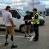Патрульний поліцейський оформлює протокол водію на паркувальному майданчику біля торгового центру, поруч стоїть чоловік на протезах ніг