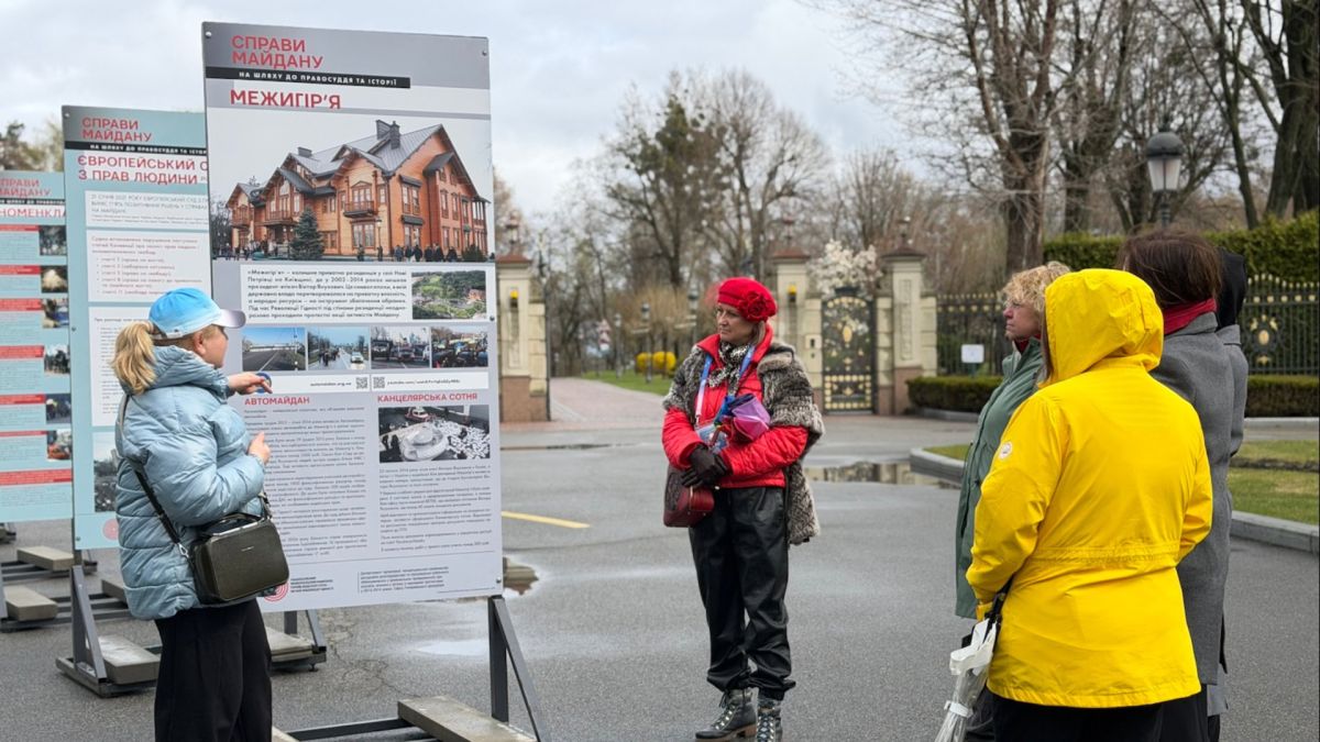 Відвідувачі розглядають банерну виставку «Справи Майдану: на шляху до правосуддя та історії» на території парку «Межигір'я» біля інформаційних стендів