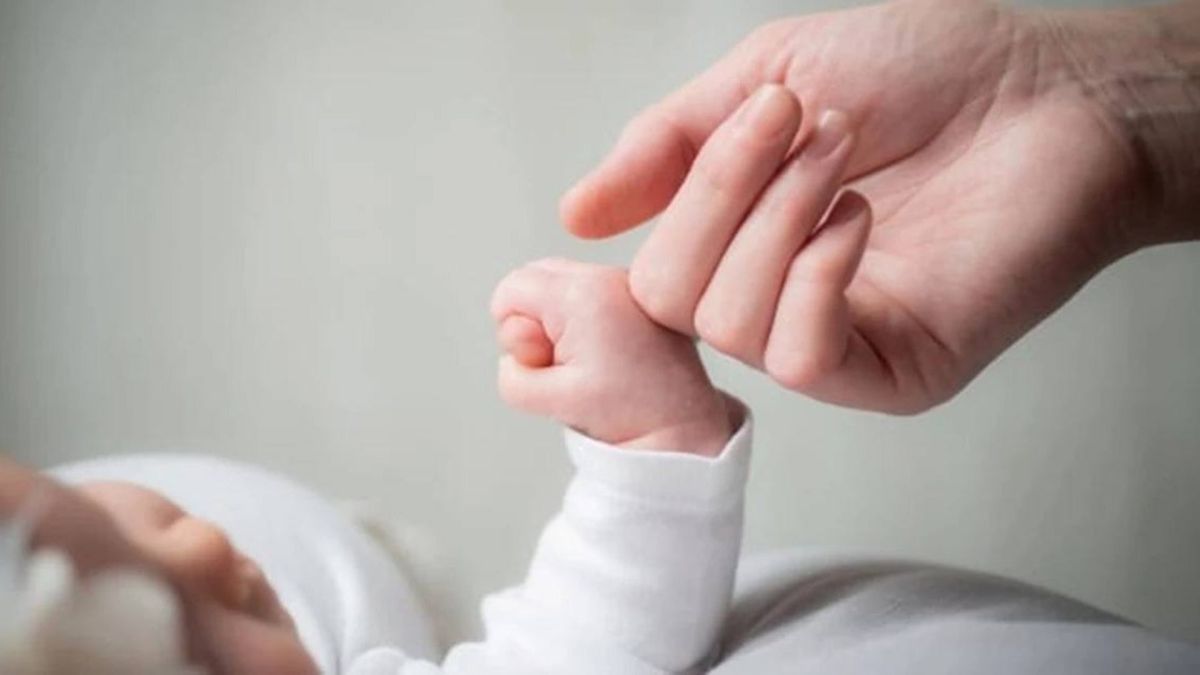 Дитина тримає дорослу людину за палець