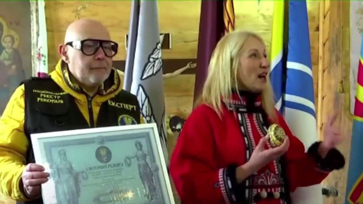 Експерт Національного реєстру рекордів вручає відзнаку організаторці ініціативи Писанка Єднання на Великдень у Пирогові