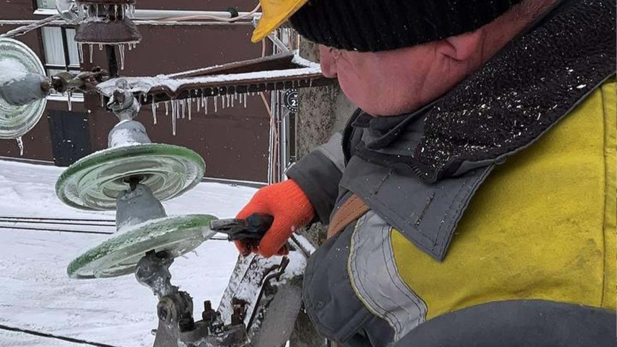 Працівник ДТЕК проводить ремонтні роботи на ліній електропередачі біля багатоповерхівки