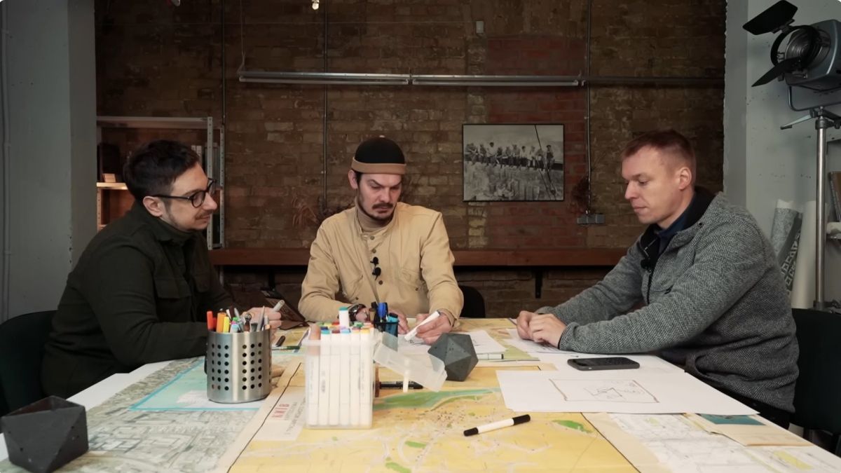 Архітектори Антон Герасимович та Віктор Герасименко обговорюють проблеми київських бюветів та міського благоустрою за столом із картами міста