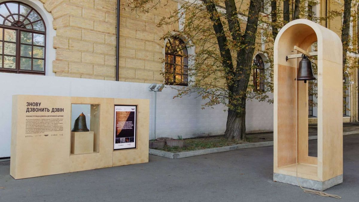 Реконструйований бронзовий дзвін Десятинної церкви у дерев’яній арці на виставковому стенді «Знову дзвонить дзвін» біля Національного музею історії України в Києві