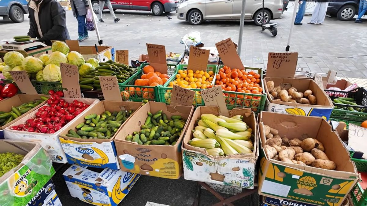 Прилавок із овочами та фруктами на ярмарку в Дарниці: огірки, кабачки, апельсини, картопля з цінниками