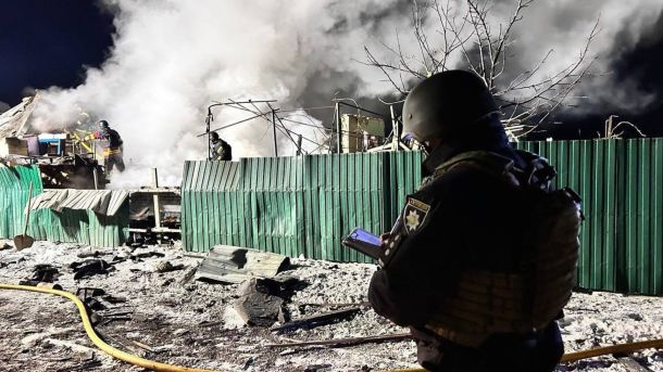 Представник правоохоронних органів оглядає руйнування після ворожої атаки