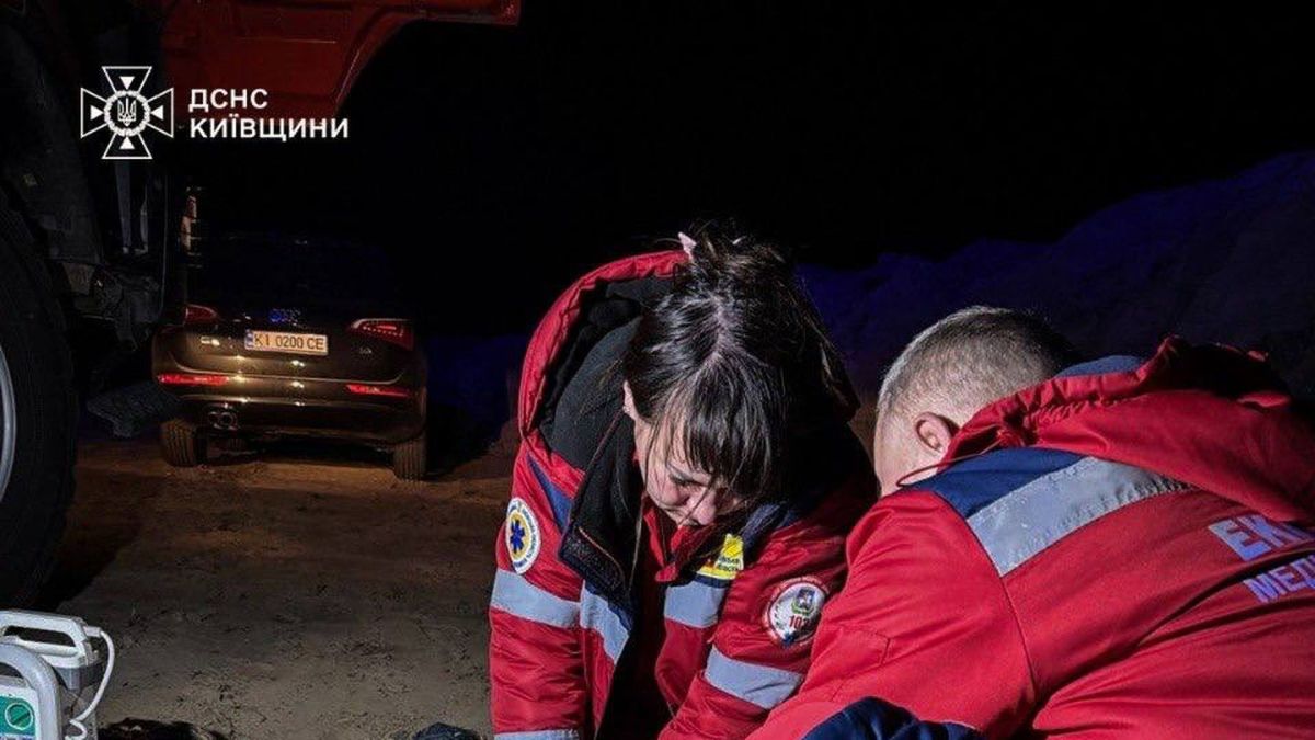 Медики рятувальної служби надають допомогу дитині біля автомобіля швидкої у Бородянці вночі