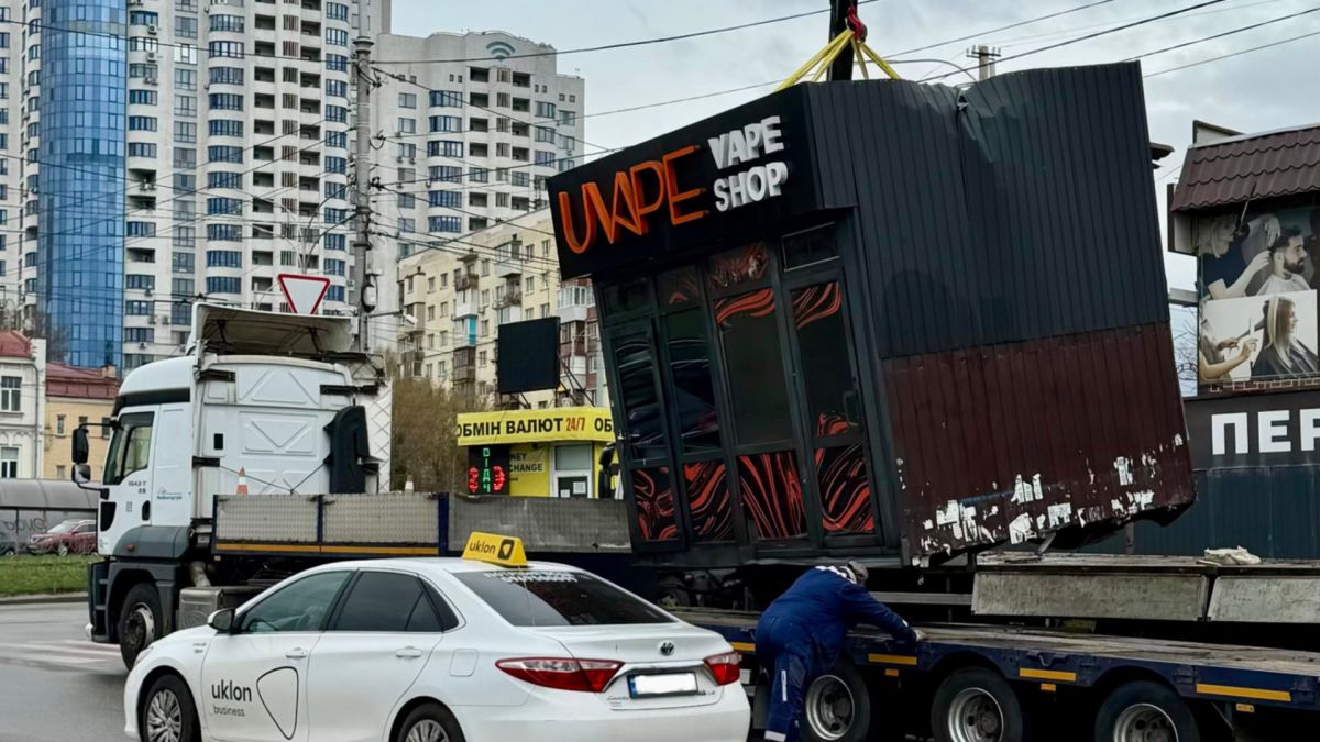 Кран піднімає незаконну тимчасову споруду вейп-шопу на Голосіївському проспекті у Києві для демонтажу