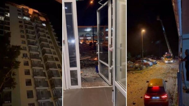 Зруйнована багатоповерхівка через ракетний удар у Києві, пошкоджена входна група будівлі, наслідки вибуху і обвалення дорожнього покриття біля автомагістралі вечерком.