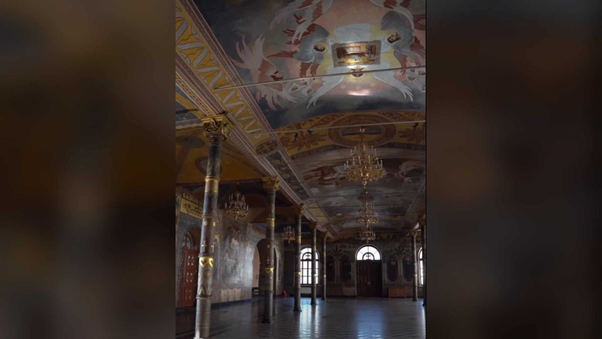 Зал Трапезної палати Києво-Печерської лаври: розписане ангелами склепіння, колони з позолотою та люстри