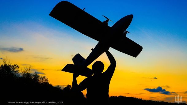 Чоловік тримає дрон на фоні неба жовто блакитного