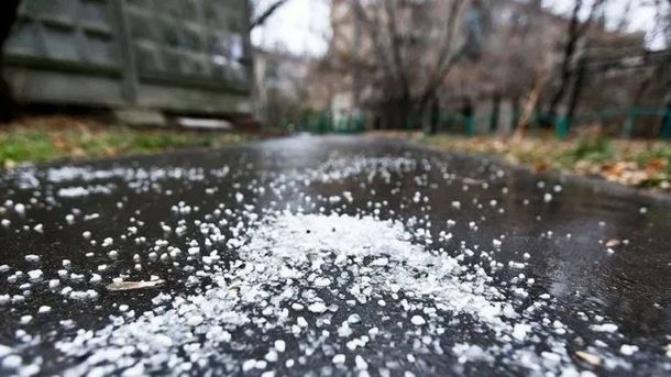 Шар білого граду на мокрому асфальті у дворі багатоповерхівки після зливи у Вишгороді на Київщині 3 липня 2026 року
