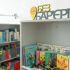 Стелажі бібліотеки з дитячими книгами та знак БЕЗ БАР'ЄРІВ у рамках інклюзивної програми Києва