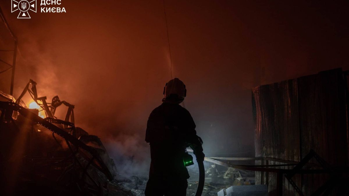 Рятувальник ДСНС Києва біля охоплених вогнем конструкцій під час гасіння пожежі в Києві після нічної атаки 30 вересня