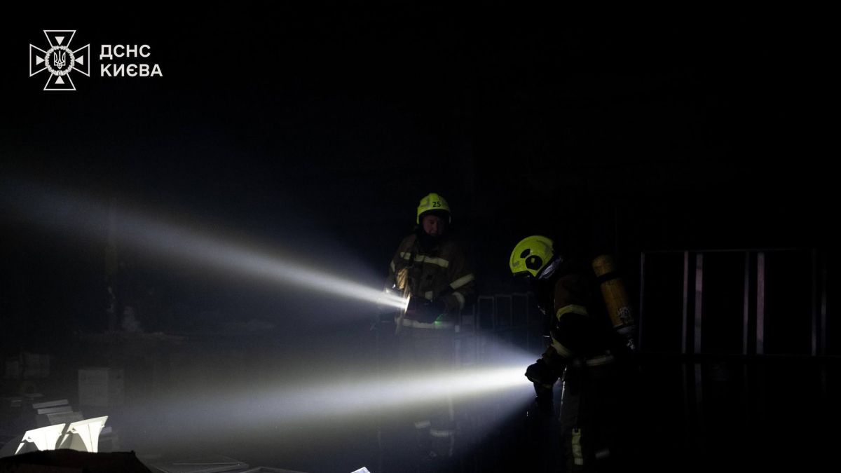 Двоє вогнеборців ДСНС Київ гасять пожежу всередині складського приміщення на вулиці Автозаводській в Оболонському районі вночі 10 квітня 2026 року