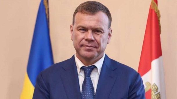 чоловік середнього віку на фоні прапорів
