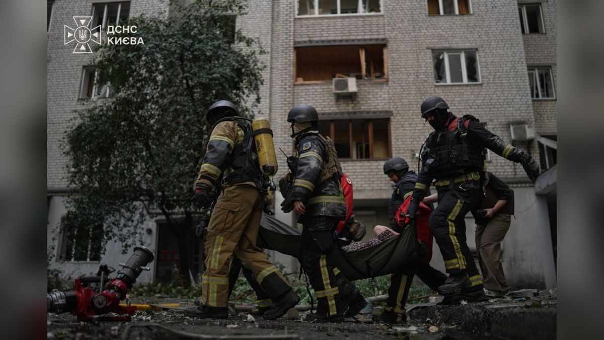 Рятувальники ДСНС виносять на ношах постраждалу від пошкодженого атакою будинку у Печерському р-ні Києва