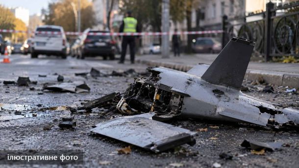 Броварська громада вшанувала пам’ять загиблих захисників 136-го батальйону Ілюстративне фото: сірий уламок дрона з розбитою носовою частиною біля кованої огорожі, поліцейський за стрічкою на вулиці